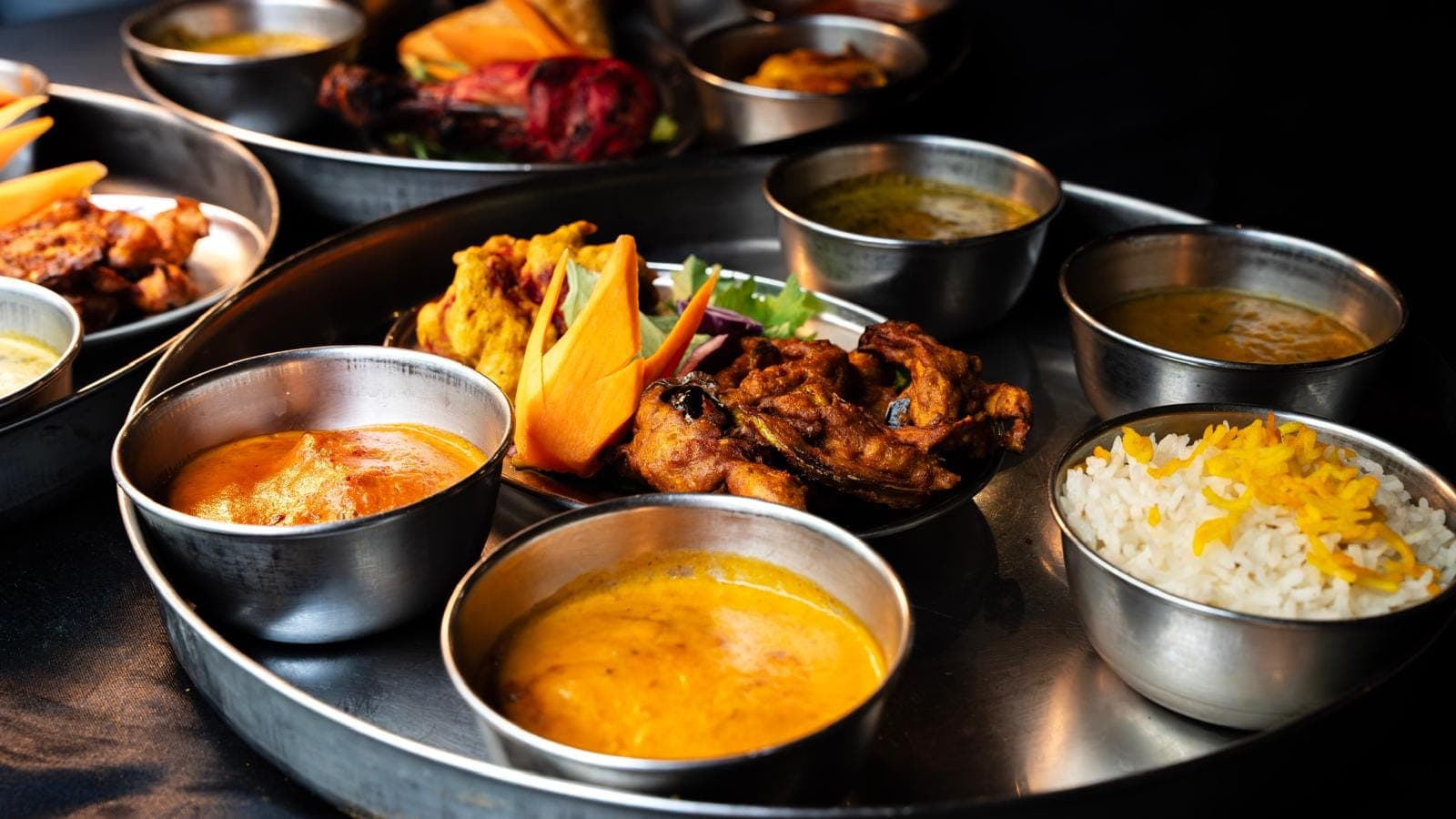 Thali indien sur plateau inox aux multiples bols de curry, dal et riz — traiteur halal d'O'Pakistan